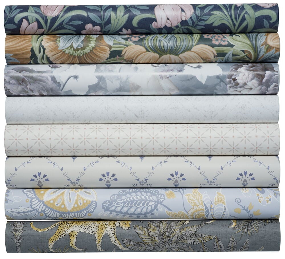 Åtta rullar tapet med olika färger och mönster.