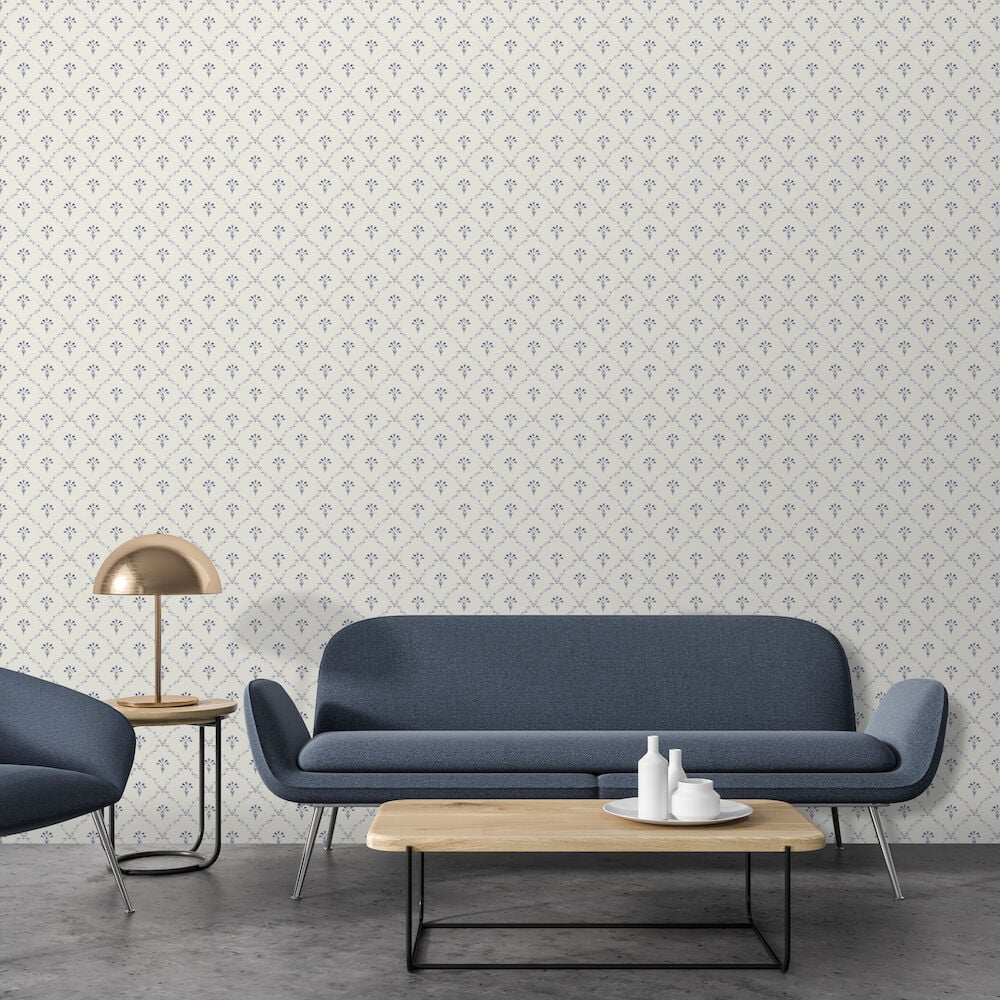 Blåklintsmönstrad tapet bakom blå soffa och soffbord.