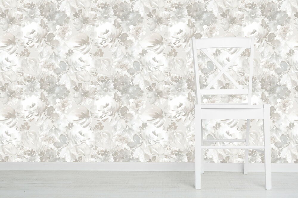 Vit stol framför blommig grå och rosa tapet.