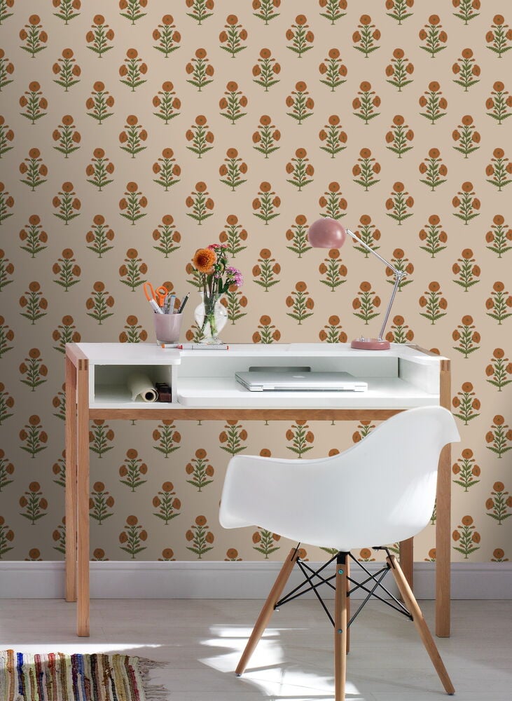 Valkoinen työpöytä ja tuoli kukallisen tapetin edessä.