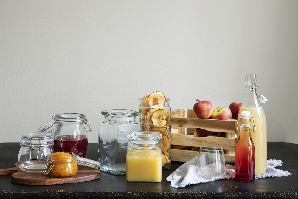 Glasburk med lock på svart bord fylld med mat.
