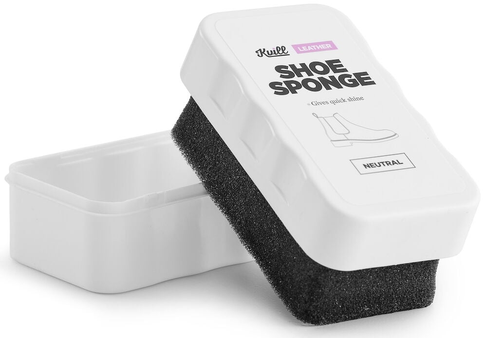 Svart skoputssvamp i vit plastask med lock.