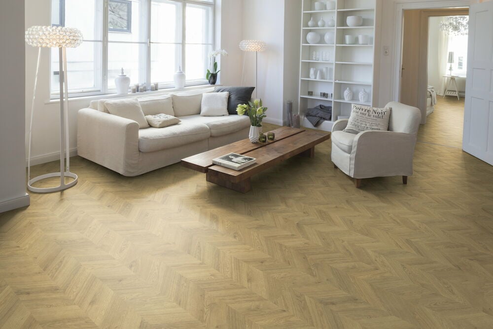 Ljust vardagsrum med laminatgolv i fiskbensmönster.