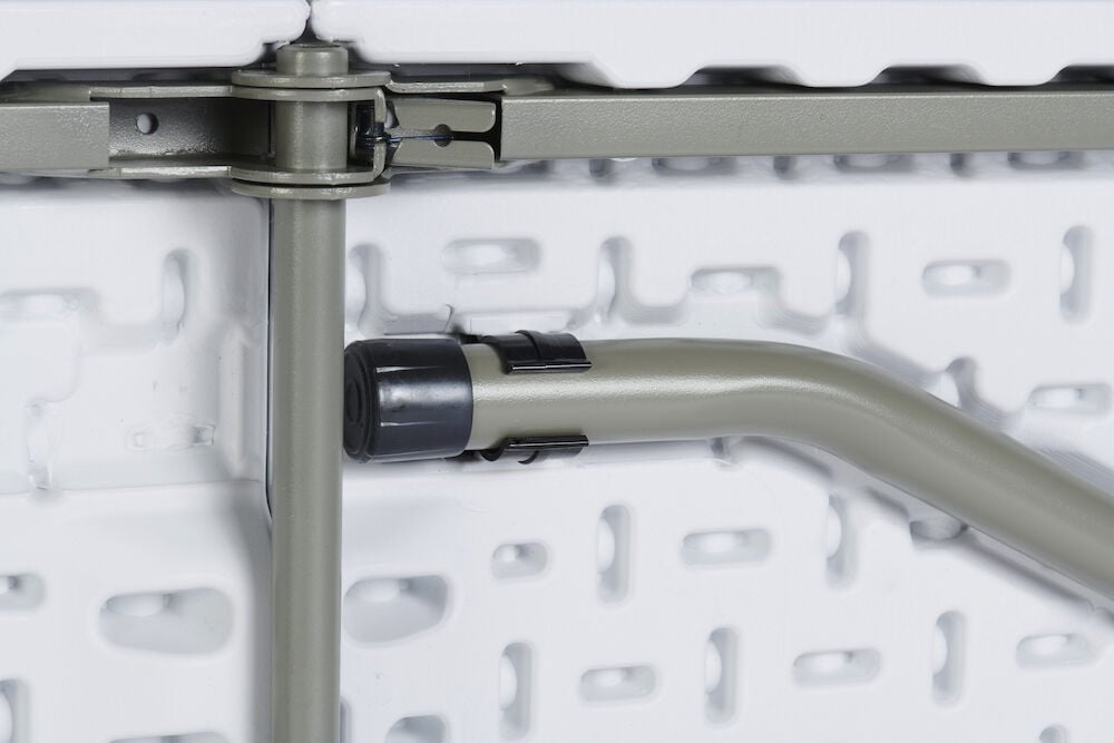 Klappbares Tischbein aus Stahl gegen weiße Kunststoffplatte.