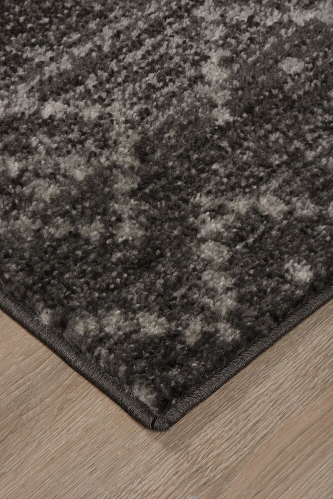 Mörkgrå matta med kort lugg på trägolv.