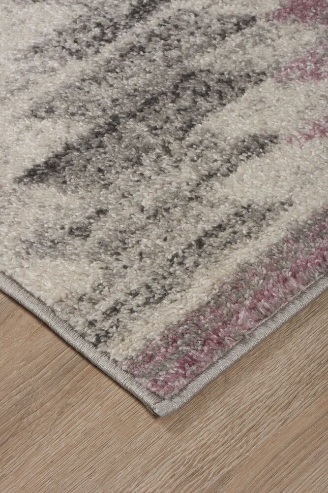 Rosa und grau gemusterter Teppich auf Holzboden.