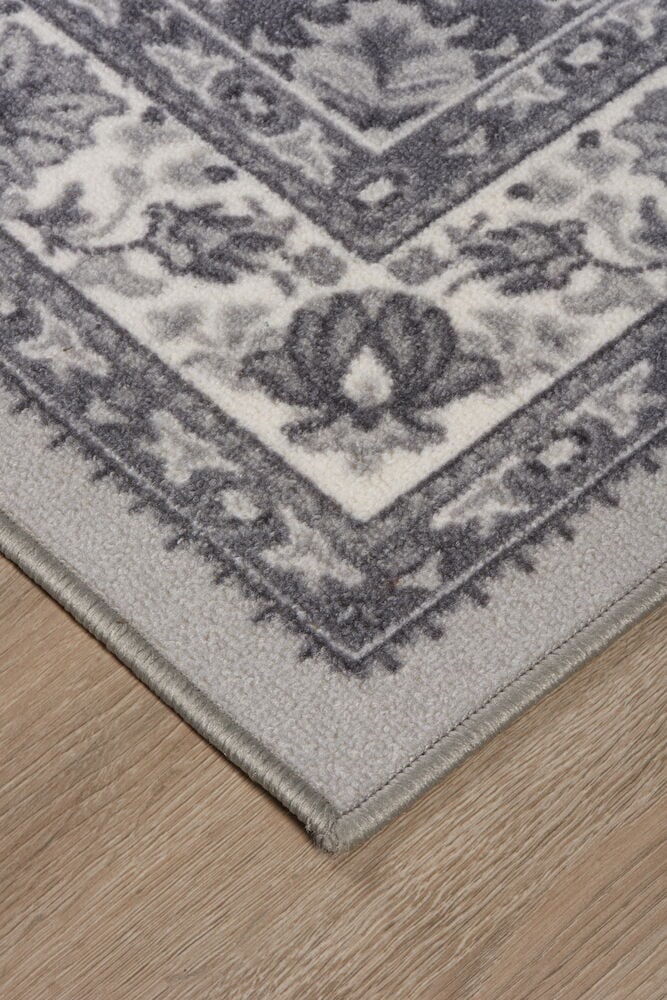 Grå matta med orientaliskt mönster på trägolv.