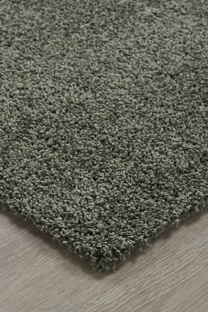 Grüner Kurzflorteppich auf hellem Holzboden.