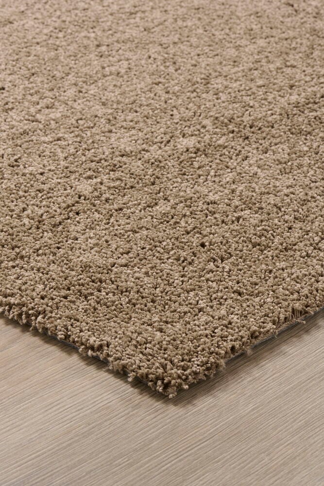 Brauner kurzer Ponyteppich auf Holzboden.