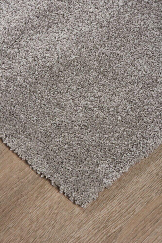 Grå matta med kort lugg på trägolv.