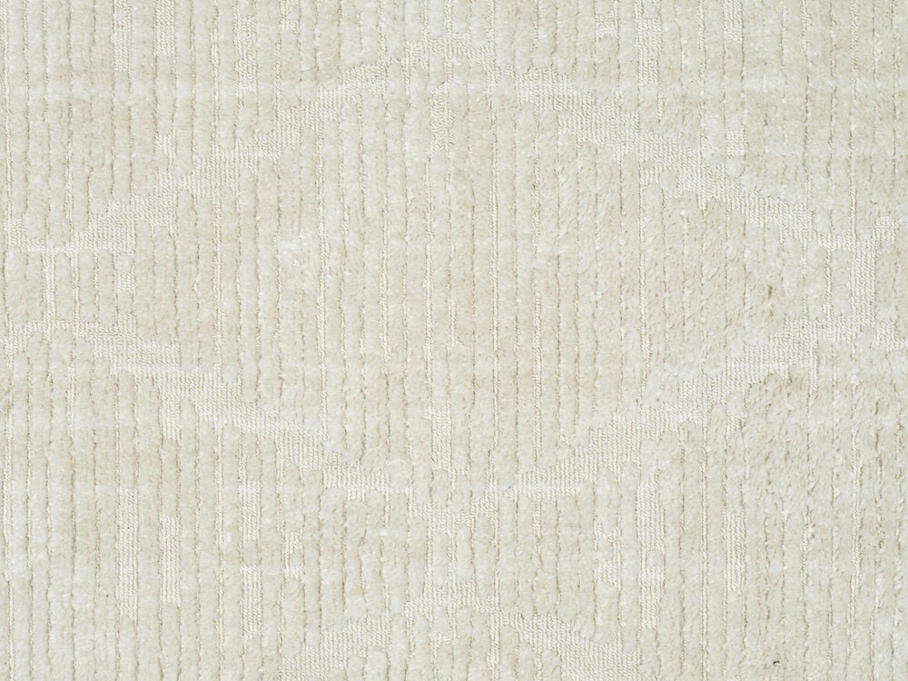 Offwhite matta med tät lugg och subtilt mönster.