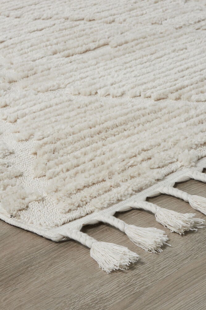 Offwhite matta med tät lugg och fransar.