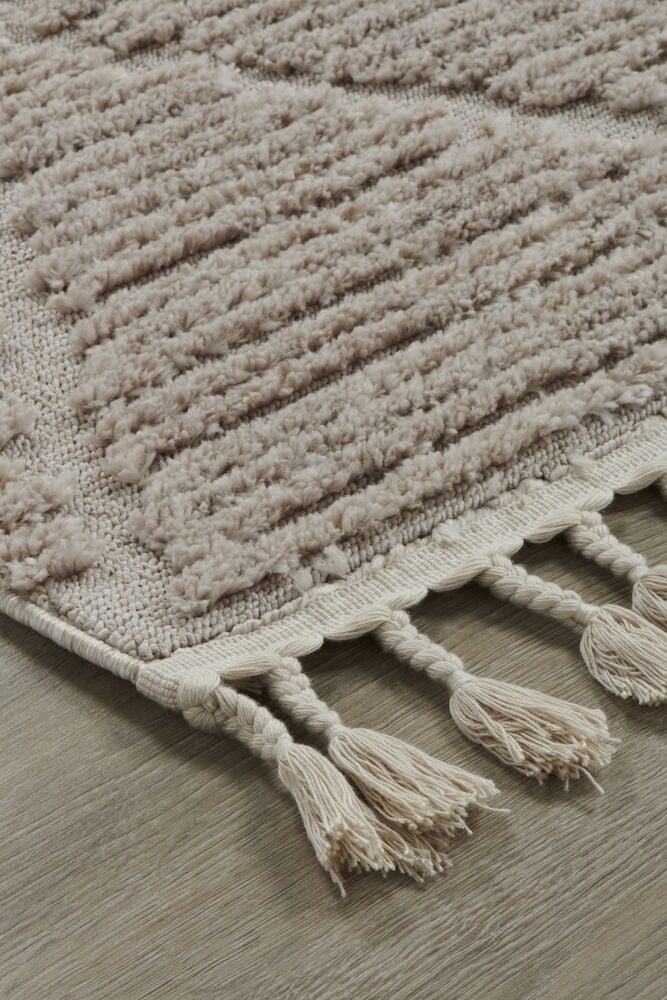 Beige matta med hög lugg och dekorativa fransar.