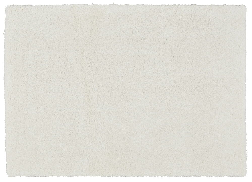Rektangulär vit matta med mjuk ull-liknande yta.