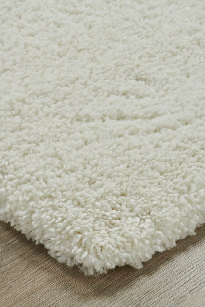 Vit tjock matta med mjuk lugg på golv.