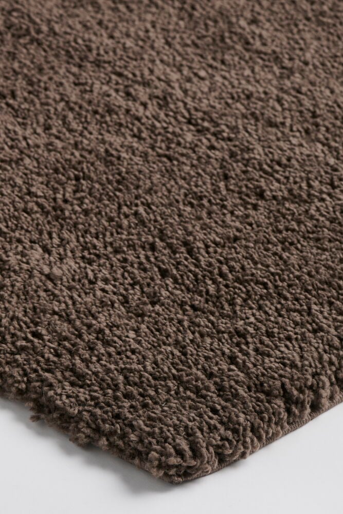 Brun Elin polypropen luggmatta med texturerad lugg, vinklad närbild.