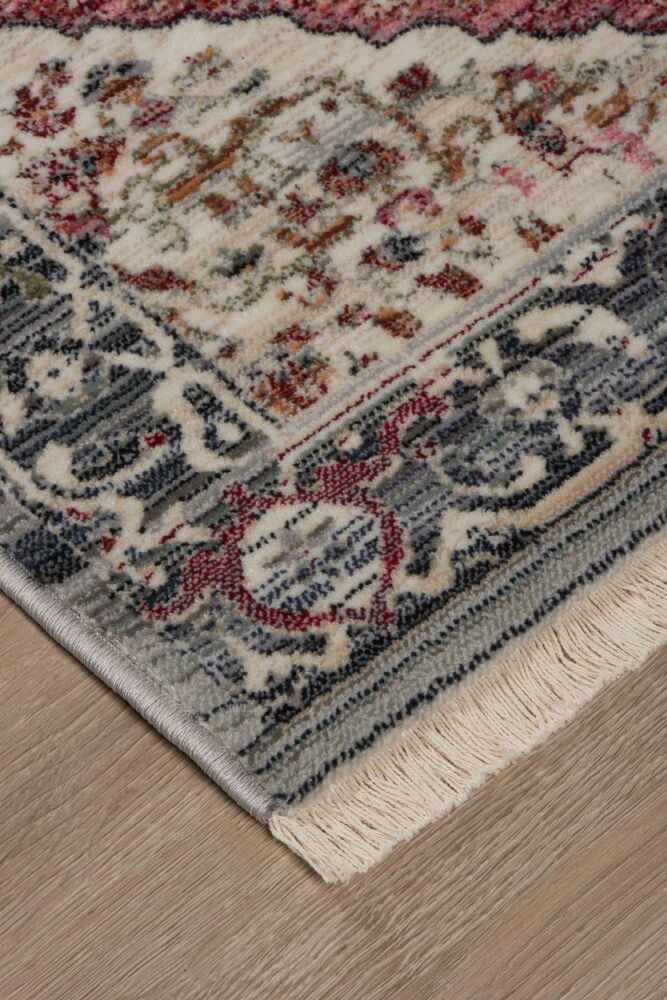 Hörn av multifärgad orientalisk matta på trägolv.