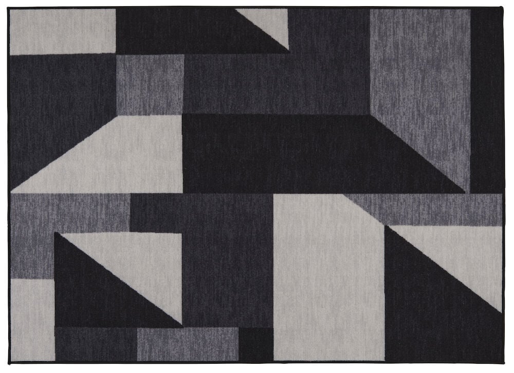 Svart matta med abstrakt blockmönster i grå nyanser.