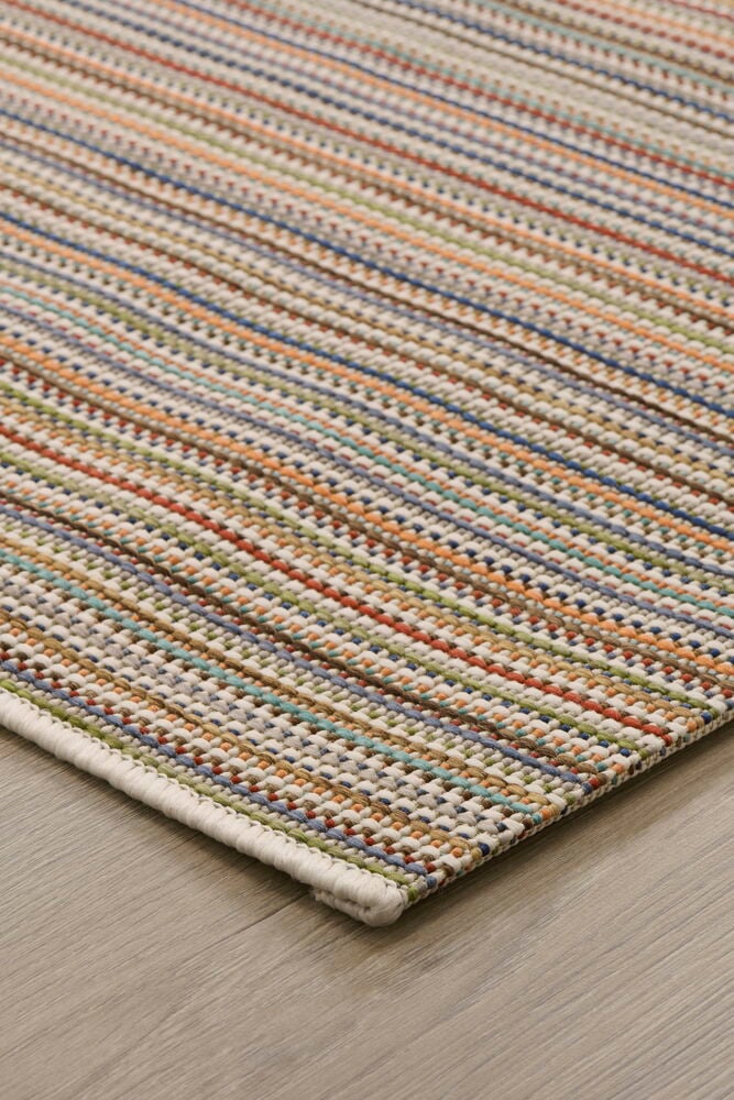 Multifärgad slätvävd matta på ljust trägolv.