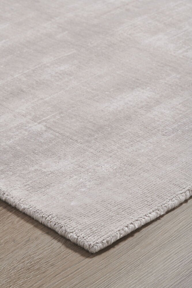 Beige handvävd matta på trägolv.