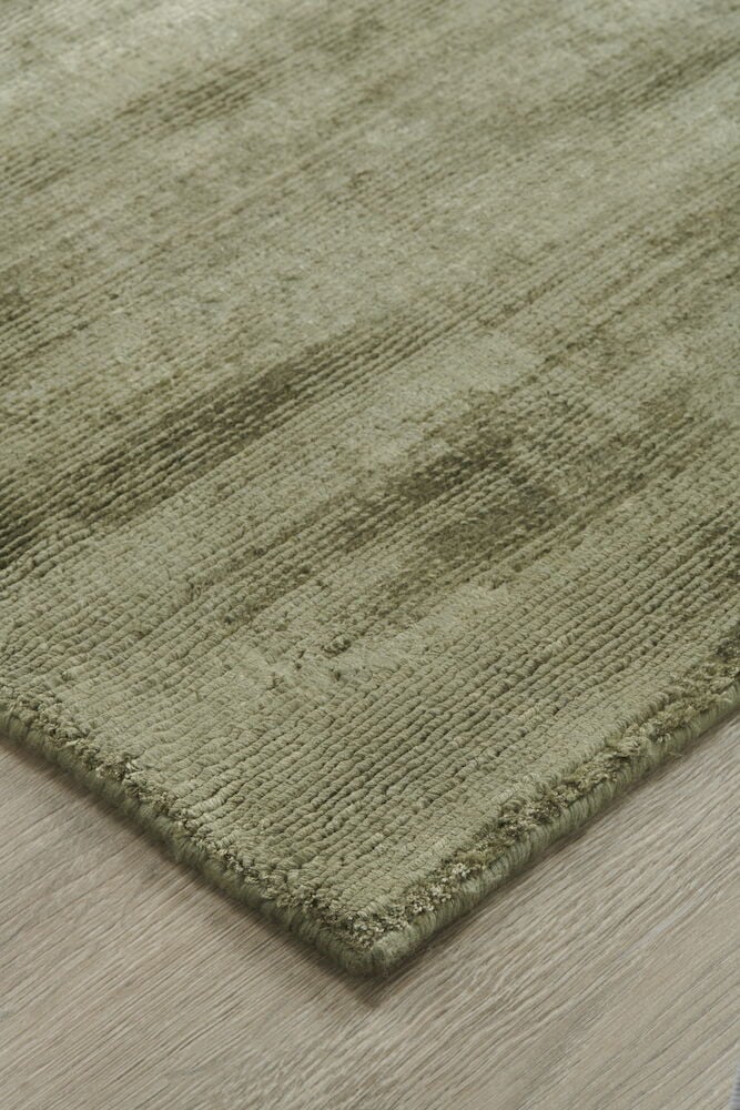Olivgrön handvävd matta med mjuk textur.
