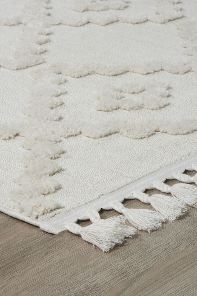 Offwhite matta med strukturerat mönster och fransar.