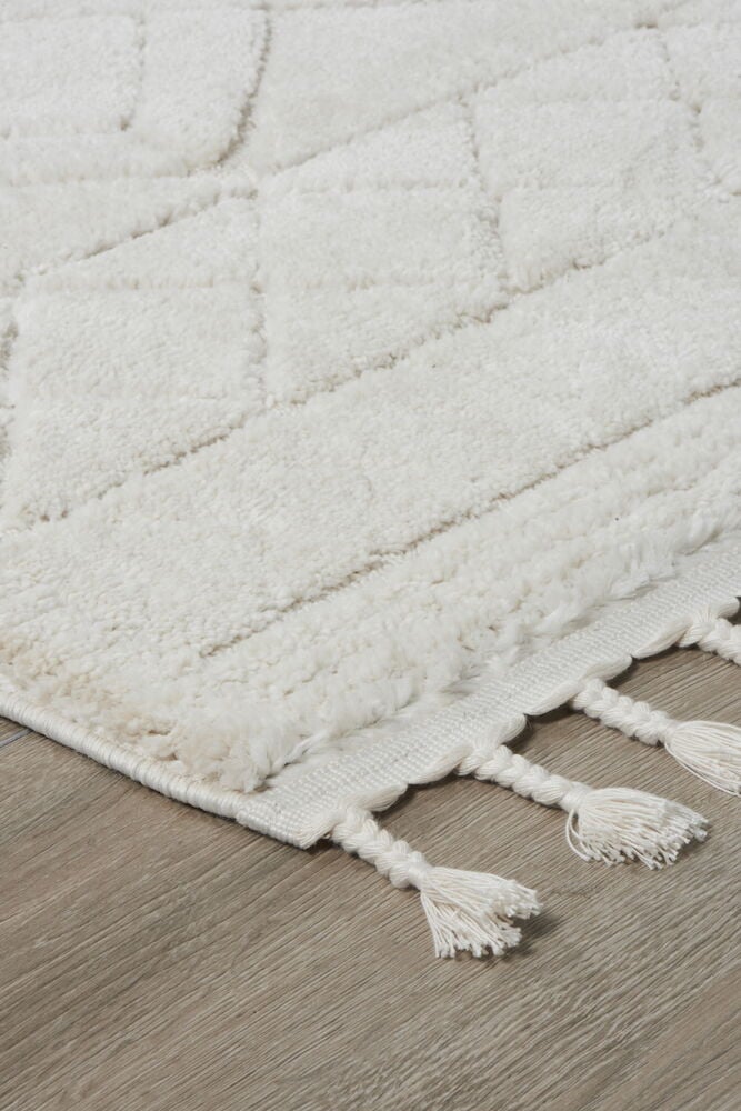 Teppich in Offwhite mit Muster und Fransen an der kurzen Seite.