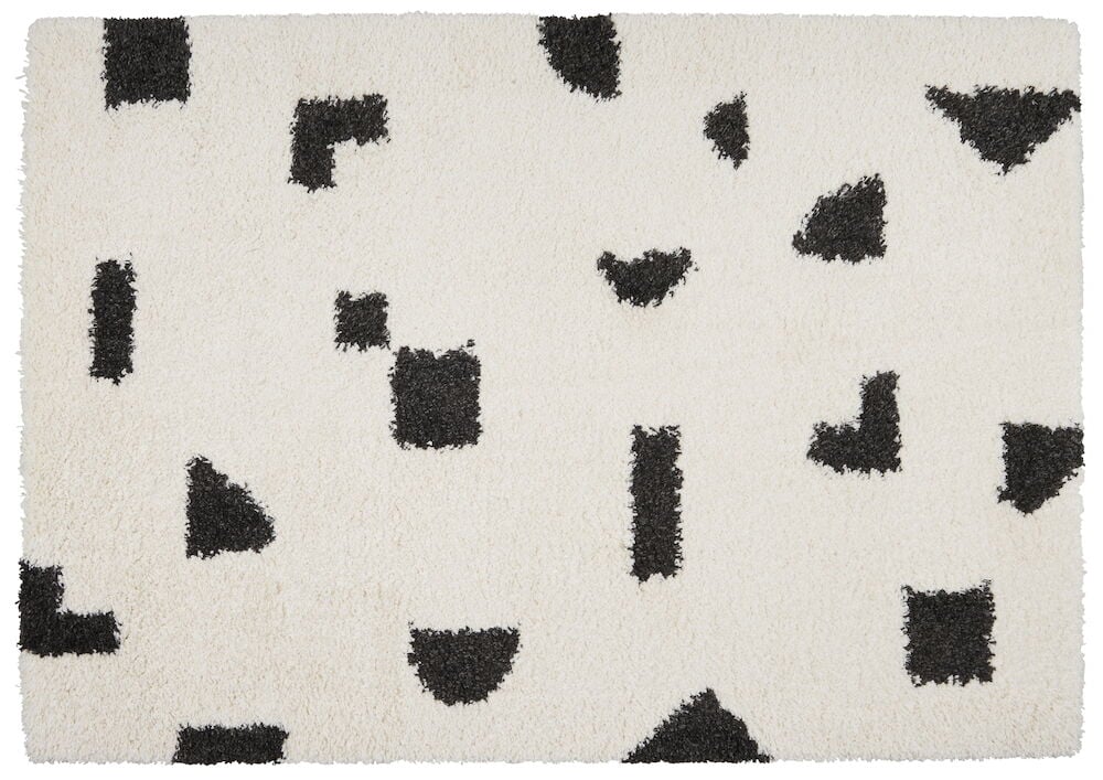 Vit matta med svart mönster i olika former.