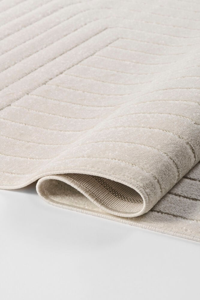 Off-white polypropen Matta Billie med texturerade böjda och raka linjer, delvis rullad.