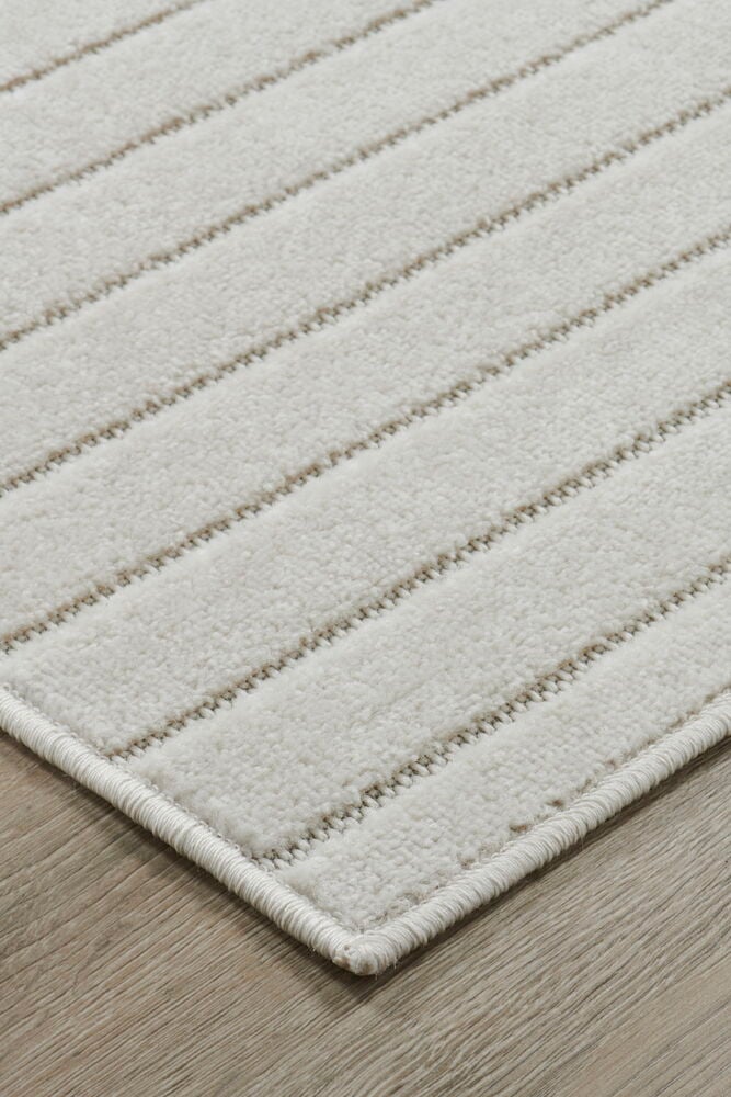 Ljus polypropenmatta med diskreta ränder på trägolv.