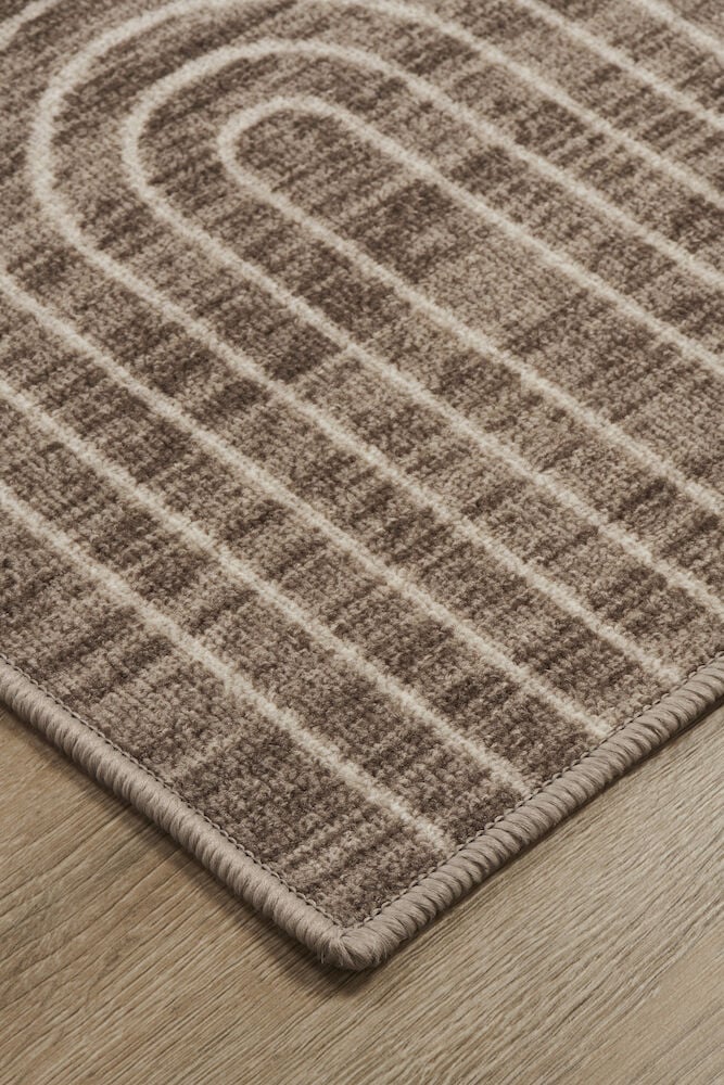 Ruskea polyamidimatto valkoisella graafisella kuviolla.