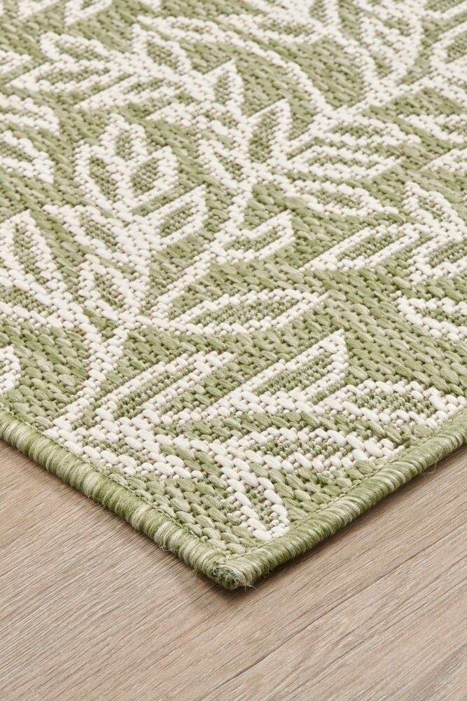 Grön flatvävd matta med ljust bladmotiv.