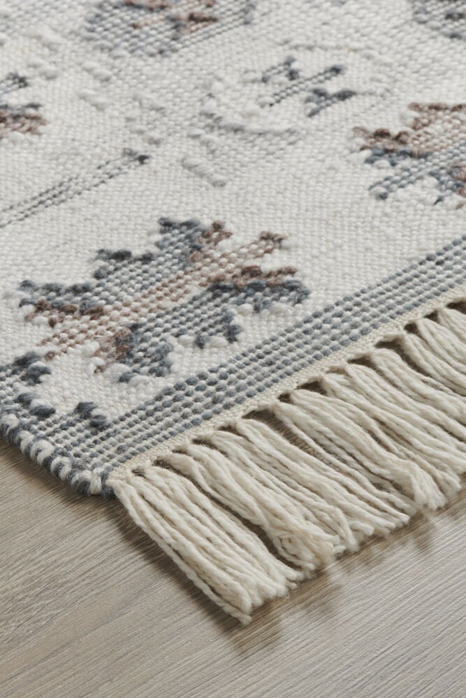 Närbild av multifärgad kelimmatta med fransar.