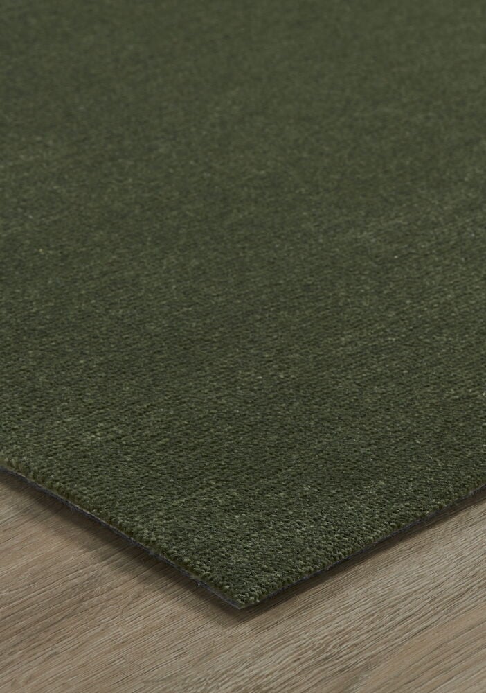 Vihreä suorakaiteen muotoinen matto puulattialla.