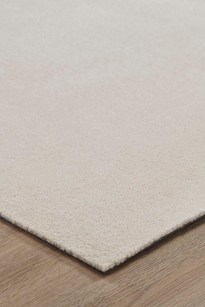 Ljus cremefärgad matta på trägolv.