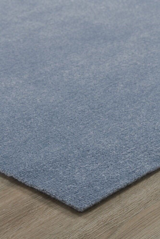 Sinisen maton kulma puulattialla.