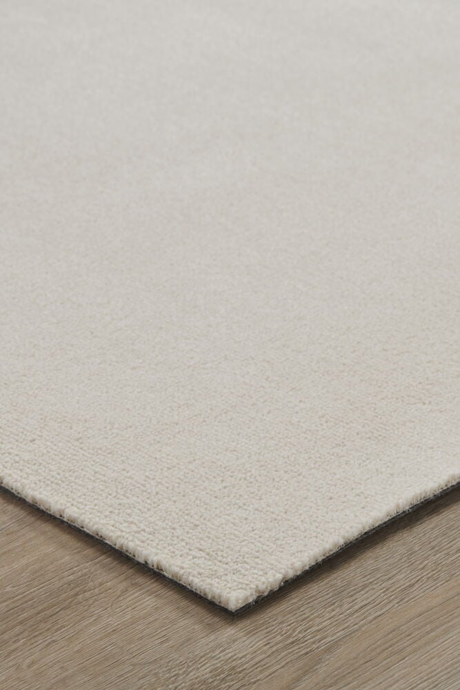 Ljus cremefärgad matta på trägolv.