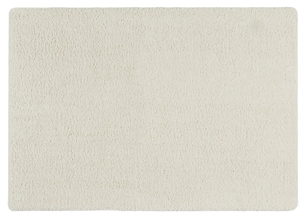 Suorakulmainen valkoinen shaggy-matto pehmeällä pinnalla.