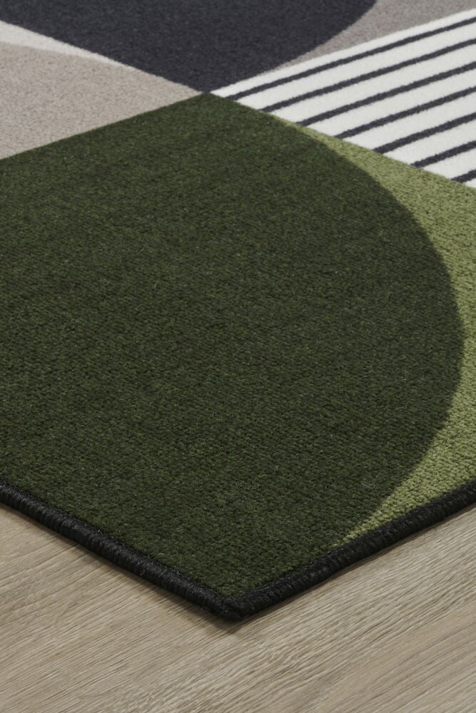 Hörn av multifärgad tuftad matta med grafiskt mönster.