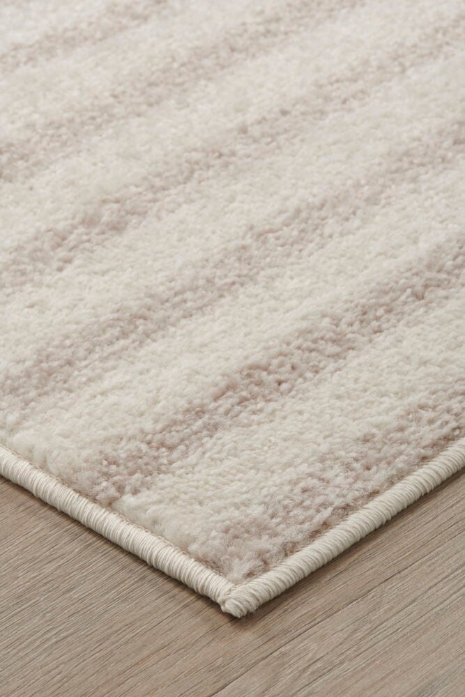 Beige matta med diskret mönster på trägolv.