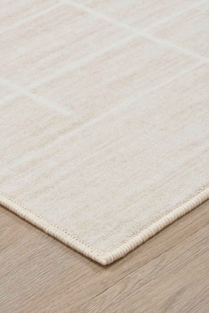 Vaaleanbeige tuftattu matto graafisella kuviolla.