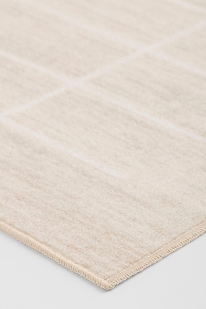 Ein hellbeige Polyamid Teppich Linn mit subtilem Streifenmuster und gesäumtem Rand.