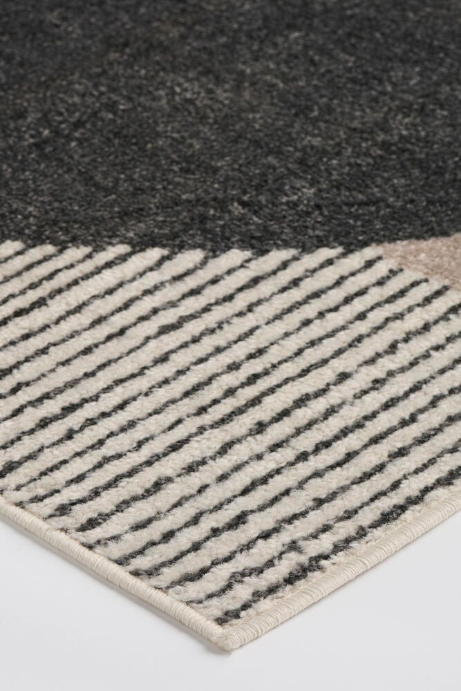 Nærbilde av Teppe Lina med grå, stripet svart-hvitt og beige geometrisk mønster.