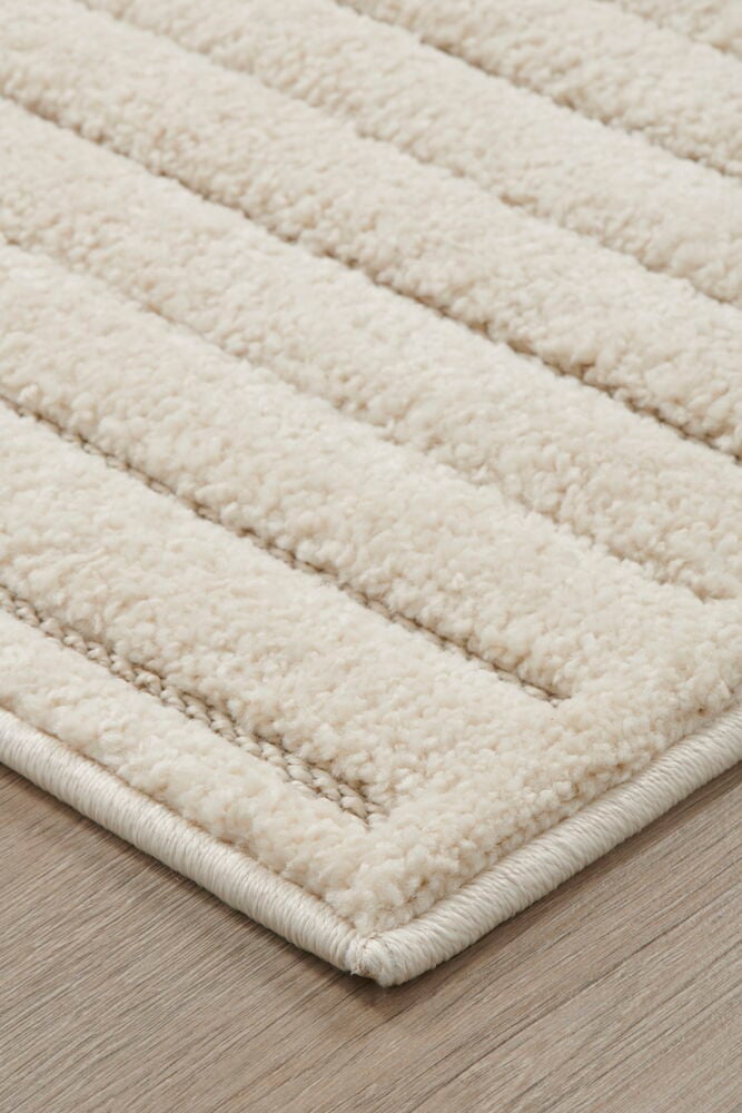 Offwhite matta med mönstrad struktur på trägolv.