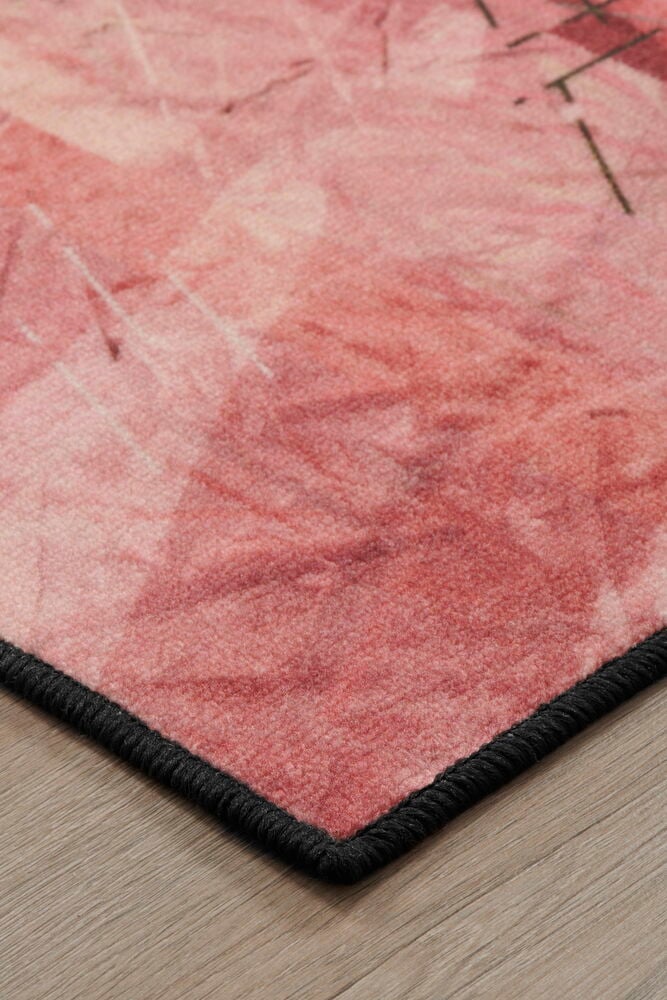 Kulma moniväristä mattoa, jossa abstrakti kuvio.