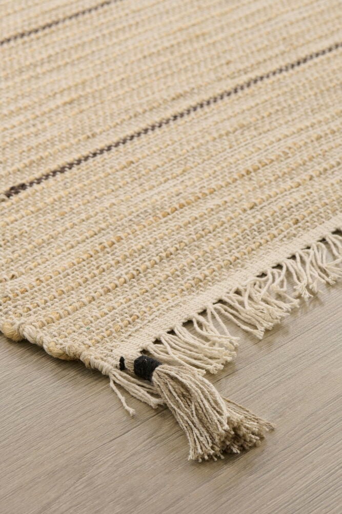 Beige matta med fransar och svarta detaljer.