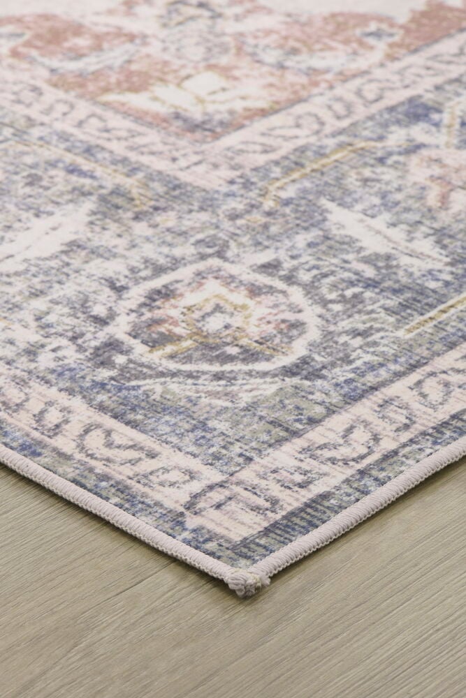 Kuvioidun maton kulma puulattialla.