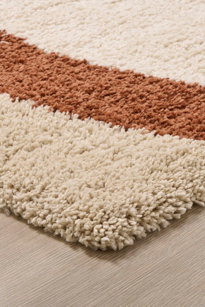 Brun och beige shaggy matta på trägolv.