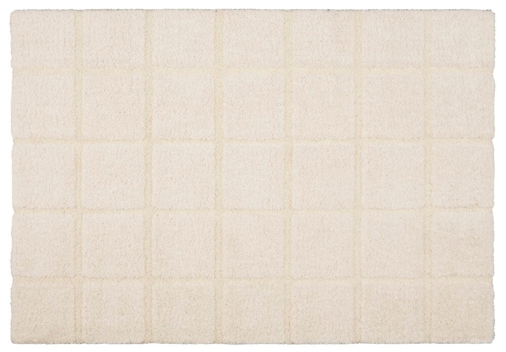 Suorakulmainen kermanvärinen matto ruutukuviolla.