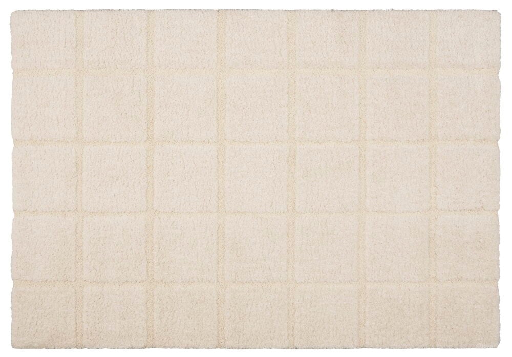 Cremefärgad matta med rutmönster och twistad lugg.